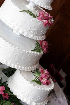 three tiered wedding cake with pink flowers on it