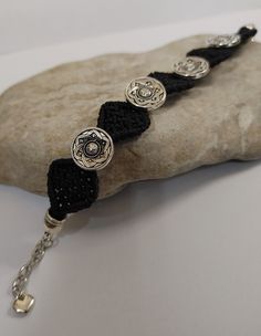 a black and silver bracelet on a rock