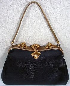 "We are pleased to off exclusively to our Etsy shoppers the wonderful Vintage Lizard Skin purse dating from the 1050's. The frame for the purse is in a gold tone finish with a hand tooled finish. There are three Iris Flowers on the top of the frame and a single Iris for the clasp All are accented with Sparkling Rhinestones and a mesh handle that also extends from the frame. Some wear to the finish of the gold coloring on the back part of the frame but, you really have to look hard to find it. Th Formal Compact Bag With Gold-tone Hardware, Compact Formal Bags With Gold-tone Hardware, Compact Evening Bags With Gold-tone Hardware, Compact Formal Bag With Gold-tone Hardware, Mid-century Gold Evening Bag, Vintage Formal Bags With Gold Clasp, Vintage Bags With Gold-tone Hardware, Vintage Evening Bag With Gold-tone Hardware, Gold Rectangular Bag For Luncheon