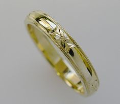 a yellow gold wedding ring with flowers on the inside and inlayed to it