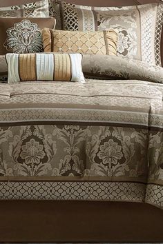 the comforter is made up with many different pillows and pillow cases on top of it