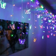 some lights that are hanging from the ceiling in front of a mirror with butterflies on it