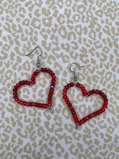 red beaded heart earrings on a leopard print background