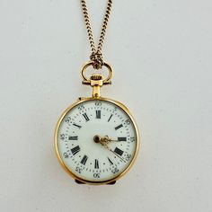 Early 1900s Antique Pocket Watch Boasting A Solid Yellow Gold Case Which Measures ~1" In Diameter. The Watch Face Features A White Enamel Dial With Black Arabic Numerals And Gold Tone Louis Xvi Style Hands. Considering Its Age And Fragility, The Dial Is In Great Condition. No Chips Or Cracks Can Be Found, And All Lettering Is Still Sharp And Clear. The Back Of The Watch Features Lovely Yellow And Rose Gold Inserts And Floral-Themed Engravings. The Back Of The Watch Can Be Opened And Personalized To Your Liking By A Qualified Jeweler. The Watch Is Not Currently Functioning And Requires Service. It Can Be Worn As A Pendant As Shown In The Pictures. The 600-Mm Long Gold Chain Is Also Included. Light Academia Jewelry, 1800s Antiques, Antique Pocket Watch, Face Features, Pocket Watch Antique, Collage Ideas, Pocket Watch Chain, Louis Xvi Style, Watch Chain