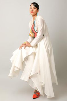 Ivory angarkha with asymmetric draped panels, landscape pattern yoke, surplice cowl neck, multi color patch, zari and thread embroidery. Paired with straight fit pant.
Components: 2
Pattern: Embroidered and Printed
Type Of Work: Applique, Thread and Zari Work
Neckline: Surplice Cowl Neck
Sleeve Type: Full Sleeves
Fabric: Silk Chanderi, Cotton Slub
Color: Ivory
Other Details: 
Fringe drop tassels
Asymmetric hem
Side elasticated waist
Back inverted pleated detail
Length:
Angarkha Back: 54 inches
A Cream Long Sleeve Set With Cutdana, White Dabka Kurta For Spring, White Designer Kurta For Spring, Designer White Long Sleeve Palazzo Set, Spring White Dabka Kurta, Spring Designer White Kurta, Designer White Palazzo Set With Dabka, White Bohemian Kurta With Traditional Drape, White Dabka Palazzo Set For Designer Wear