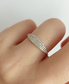 a woman's hand with a diamond ring on top of her finger and the band is