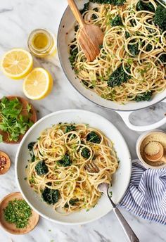 two bowls filled with pasta and broccoli on top of a marble countertop