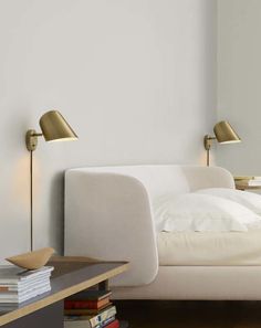 a white bed with two lamps on each side