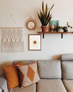 a living room filled with furniture and plants on top of a shelf above a couch