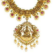 Designed with the elegance, this 22k antique gold Lakshmi necklace set by Virani Jewelers features rubies, emeralds, pearls and cubic zirconia stones. The antique gold finish offers a sophisticated, vintage look, while the gemstones add a vibrant contrast. Ideal for formal events and celebrations, this 22k gold Lakshmi necklace is a beautiful representation of traditional craftsmanship, blending heritage and contemporary style for those who appreciate luxurious, meaningful Indian jewelry.Features• 22k yellow gold• Antique finish• Engraved details• Emerald• Ruby • Pearl• Cubic zirconiaSpecifications:• Minimum Width - 2.5 millimeters• Maximum Width - 61.6 millimeters• Length - 30 inches• Weight - 111.7 grams Traditional Luxury Engraved Necklaces, Gold Necklace Set Indian Kameswari Jewellers, Luxury 22k Gold Engraved Necklaces, Luxury Antique Necklaces For Celebration, Short Gold Necklace Kameswari Jewellers, Gold Necklace Set Kameswari Jewellers, 22k Gold Necklace Addiga, 22k Gold Necklace Indian Jewelry Kameswari Jewellers, Luxury Traditional Pearl Necklace With Gemstones