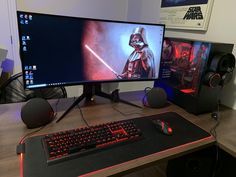 a computer desk with a keyboard, mouse and monitor on it in front of a star wars poster