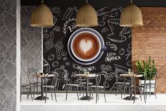 the interior of a coffee shop with tables and chairs in front of a chalkboard wall