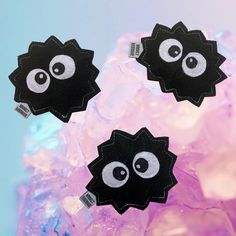 three black and white stickers with eyes on them in front of ice cubes