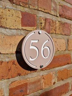 a sign that is on the side of a brick wall with a number in it