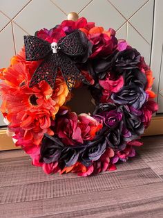 a colorful wreath with black and orange flowers