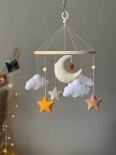 a mobile with stars, moon and clouds hanging from it