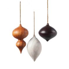 three wooden ornaments hanging from chains on a white background