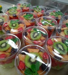 several plastic containers filled with different types of fruit