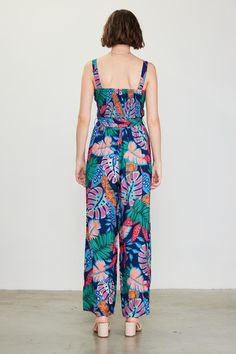 Fun, colorful, and impossible to ignore in a tropical floral print, this strappy jumpsuit is the ideal way to spice up your warm-weather wardrobe. It's got a smocked bodice that's balanced by a wide, roomy cut through the legs. A self-tie belt completes the look. "•Gathered shoulder straps •Smocked bodice •Ruffle trim at neckline •Optional self-tie belt •Wide-leg silhouette Item Number: 74403 SELF: 80% RAYON 20% NYLONE LINING: 100% RAYON Spring Summer Strapless Jumpsuit With Floral Print, Spring Strapless Jumpsuit With Floral Print For Summer, Spring Strapless Jumpsuit With Floral Print, Summer Beach Floral Print Strapless Jumpsuit, Sleeveless Tropical Print Jumpsuits For Spring, Summer Floral Print Jumpsuit Overall, Summer Floral Print Jumpsuits And Rompers, Summer Floral Print Overall Jumpsuits And Rompers, Floral Print Strapless Jumpsuit For Vacation