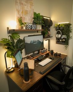 a desk with a computer monitor, keyboard and mouse next to a potted plant