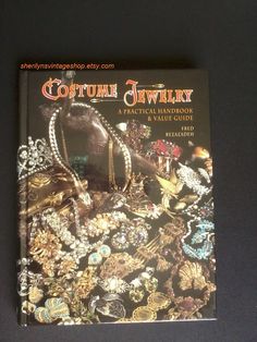 Costume Jewelry, A Practical Handbook & Value Guide Author: Fred Rezazadeh Copyright 1993  Published by Collector Books Photos Pitkin Studio Vintage Hardcover 253 pages including index This book is in excellent, clean vintage condition with few signs of age or use. Back and front covers have some very light surface scratches.   The spine is in excellent shape with no loose or missing pages.  I have not found any writing, markings, stains, creases, or rips on any pages in this book. Got Costumes, Rhinestone Sweater, Vintage Rhinestone Brooch, Sweater Clip, Bar Graphs, Cover Photo, Stunning Jewellery, Vintage Costume Jewelry, Vintage Rhinestone