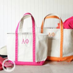 two canvas totes with monogrammed letters on them sitting next to each other