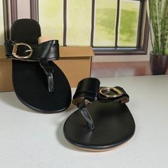 Black And Gold Flip Flop Sandals Black Flat Flip Flops For Vacation, Trendy Black T-strap Sandals With Round Toe, Black Toe Ring Sandals With Buckle Closure For Summer, Black Trendy T-strap Sandals, Black Flip Flops With Buckle Closure For Summer, Black Flat T-strap Sandals In Synthetic Material, Black Flat T-strap Sandals In Synthetic, Adjustable Black Flip Flops With Buckle, Black T-strap Sandals With Single Toe Strap For Beach