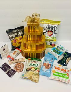 an assortment of snacks are arranged in a tower on a white table top, including chips and crackers