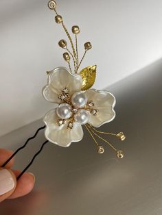 This handmade floral gold hairpin - features a delicate white pearl flower crafted with gold-colored wire, adorned with small gold beads, and leaves, and secured with a bobby pin. 🌼Perfect for a classy, messy, or textured wedding updo. 🌼This versatile bridal hairpiece adds a touch of sophistication to any wedding gown design.  With a length of 8cm (3.1 inches) It is ready to ship. If you liked this hair piece, you could like also those hair pins, take a look: https://visageroomdesigns.etsy.com/listing/1657905358 https://visageroomdesigns.etsy.com/listing/1670786761 Bridal Side Hair, Side Hair Clip, Side Hair, Bridal Hairpiece, Flower Hair Pieces, Victorian Hairstyles, Gold Hair Pin, Bride Hair, Big Pearl