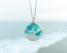 This nautical necklace, a real starfish necklace, is a very refreshing complement for this summer. A beach wedding necklace as the most original beach-lover gift for women. Wearing this nautical necklace you will have the ocean always with you. A real starfish necklace that can be used as a beach wedding necklace to make your most unforgettable moments immortal. The hypoallergenic stainless steel chain and the high-gloss crystalline resin give this nautical necklace a precious and enameled look. Ocean-inspired Jewelry For Vacation, Adjustable Ocean-inspired Necklace, Strand Necklace With Lobster Clasp As Gift, Strand Necklace With Lobster Clasp For Gift, Gift Necklace With Lobster Clasp And Strand Shape, Ocean-inspired Strand Necklaces For Beach Season, Ocean-inspired Strand Necklace For Beach Season, White Ocean-inspired Charm Necklace For Gift, Ocean-inspired Necklaces For Summer Gifts