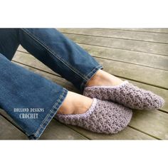 a woman's feet wearing crochet slippers sitting on a wooden deck