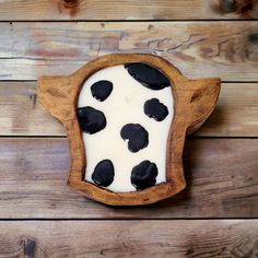 a wooden bowl filled with black and white food on top of a wooden table next to a wall