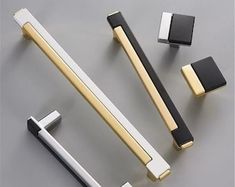 an assortment of handles and knobs on a gray surface with black, white and gold accents