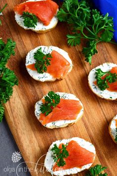 small appetizers with smoked salmon and parsley on top are ready to be eaten