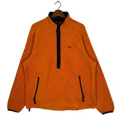 an orange jacket with black zippers on the front and back, hanging from a hanger