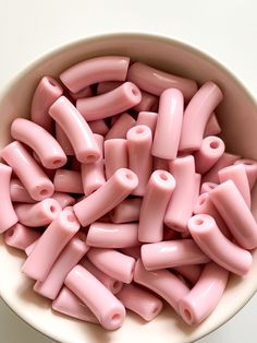 a bowl filled with pink plastic beads on top of a table