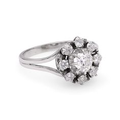 an antique diamond cluster ring, set in 18ct white gold and featuring round brilliant cut diamonds