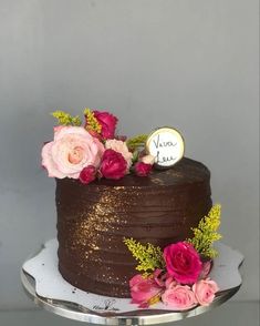 a chocolate cake with pink flowers on top