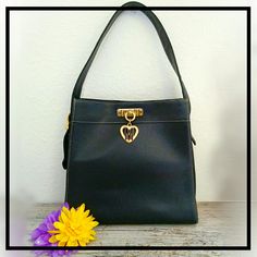 Preowned Vintage Moschino Cheap And Chic Classic Black Leather Shoulder Bag. Features Moschino Cheap & Chic Gold Tone Signature Logo Embossed On Back, Ykk Zipper Compartment On Top Back Exterior, Gold Tone Heart Charm In Front For Magnetic Top Closure, The Classic Black Moschino Signature Fabric Interior Lining W/1 Ykk Zipper Compartment Inside, & 1 Buckle Strap For Adjustment. Measures Approx 11½" Wide, 11½" Long, 4½" Depth, & 9" Adjustable Strap Drop.Good Condition W/Minor Rub Wear To Leather. Vintage Moschino, Moschino Bags, Adjustable Bag Strap, Black Leather Shoulder Bag, Moschino Cheap And Chic, Purse Fashion, Adjustable Bag, Handbag Handles, Shoulder Messenger Bag