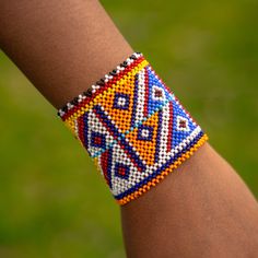 This handmade African bracelet is the ultimate statement piece. Made with traditional Maasai beads, these bright and beautiful pieces will add the perfect finishing touch to any outfit. In East Africa, every beaded ornament we adorn tells a story and we're proud to tell our stories about our culture. These are traditionally worn by individuals of any gender. We embrace and appreciate people from every culture, especially those who share in our love for these beautiful and brightly beaded pieces!