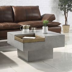 a coffee table sitting on top of a white tile floor next to a brown leather couch