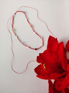 Red beaded sparkly necklace inspired by amaryllis flower. Made from long red glass beads, freshwater pearls and big vintage beads. The long cords can be worn in front for a more playful look. At the end of the each cord are red ruby jade gemstones. Necklace has a sliding knot. Wax cord is adjustable, length up to 110 cm. It can be cut for shorter cords. Each jewelry piece comes in Snasty branded packaging and personalised message printed on a typewriter. Let me know while ordering which message you would like to have printed or it can be a surprise! Handmade Red Beaded Lariat Necklace, Red Long Beaded Necklaces For Gifts, Red Beaded Pearl Necklace For Party, Red Beaded Long Necklace As Gift, Adjustable Red Pearl Necklace, Red Beaded Long Necklace For Gift, Red Adjustable Lariat Necklace, Adjustable Red Beaded Long Necklace, Red Long Beaded Necklace With Faceted Beads