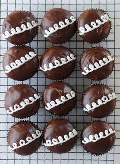 chocolate cupcakes decorated with white icing on a cooling rack, ready to be eaten