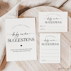 three wedding suite cards on top of a wooden platter next to a white napkin