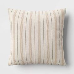 a striped pillow on a white wall with a black and tan stripe pattern in the middle