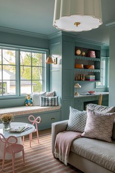 a living room filled with lots of furniture next to a window covered in bookshelves