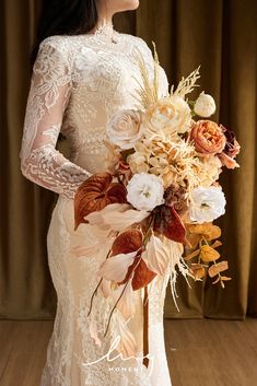 a woman holding a bouquet of flowers in her hand and wearing a white wedding dress