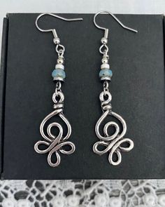 Silver Celtic inspired knot drop earrings. This earring is a finer style earring and lightweight to wear. The Celtic inspired knot is a silver plated charm. To join the charm to the earring hooks  I have used non magnetic hematite beads in silver and white, with a Czech pressed glass bead, in mauve or green. The earring hooks are stainless steel. The total drop of the earring, measured from the top of the earring hook is 60mm or 2 ½ inches. ♥︎ STAINLESS STEEL EARRING HOOKS  Stainless earring hoo Bohemian Silver-plated Drop Earrings, Bohemian Silver Plated Drop Earrings, Bohemian Silver Plated Wire Earrings For Jewelry Making, Handmade Bohemian Silver-plated Earrings, Handmade Bohemian Silver Plated Earrings, Bohemian Nickel-free Silver-plated Wire Earrings, Silver Bohemian Beaded Earrings For Gift, Distinctive Silver Wire Wrapped Beaded Earrings, Unique Silver Wire Wrapped Beaded Earrings