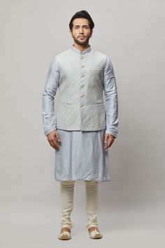 Cotton Linen blended kurta with Ivory thread & gold sequence intertwined embroidered vest plus contrasting churidar. The cotton-linen blend makes it one of our lightest and most breathable kurtas. Crafted with a collar neckline, full sleeves, and front button closure. Occasion: Can be worn to events like Sangeet, Mehendi, & Wedding WASH CARE INSTRUCTIONS - Please Dry clean only when it is applicable. Slight color variation is possible due to digital photography. Fitted Nehru Jacket In Cotton Silk With Straight Cut, Fitted Cotton Silk Nehru Jacket, Fitted Nehru Jacket In Cotton Silk, White Cotton Silk Fitted Nehru Jacket, White Fitted Nehru Jacket In Cotton Silk, White Fitted Cotton Silk Nehru Jacket, Festive Cotton Silk Fitted Nehru Jacket, Elegant Sleeveless Kurta For Transitional Season, Mehendi Wedding