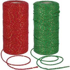 two spools of green and red twine next to each other on a white background